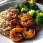 Close-up of a Honey Garlic Shrimp Bowl Quick Dinner featuring glazed shrimp, brown rice, and steamed broccoli florets.
