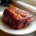 A thick, perfectly cooked Honey Glazed Ham Steak in the Skillet, glistening with a dark, rich honey sauce and sprinkled with sesame seeds.