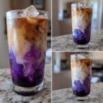Close-up of a vibrant Iced Lavender Latte showing purple syrup, white milk, and brown espresso swirling over ice.
