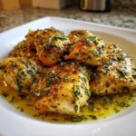 Close-up of golden-brown Lemon Garlic Chicken Skillet pieces coated in a bright herb and garlic sauce.