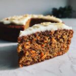 Close-up of a thick slice showing the texture of Moist Carrot Cake with Cream Cheese Frosting.