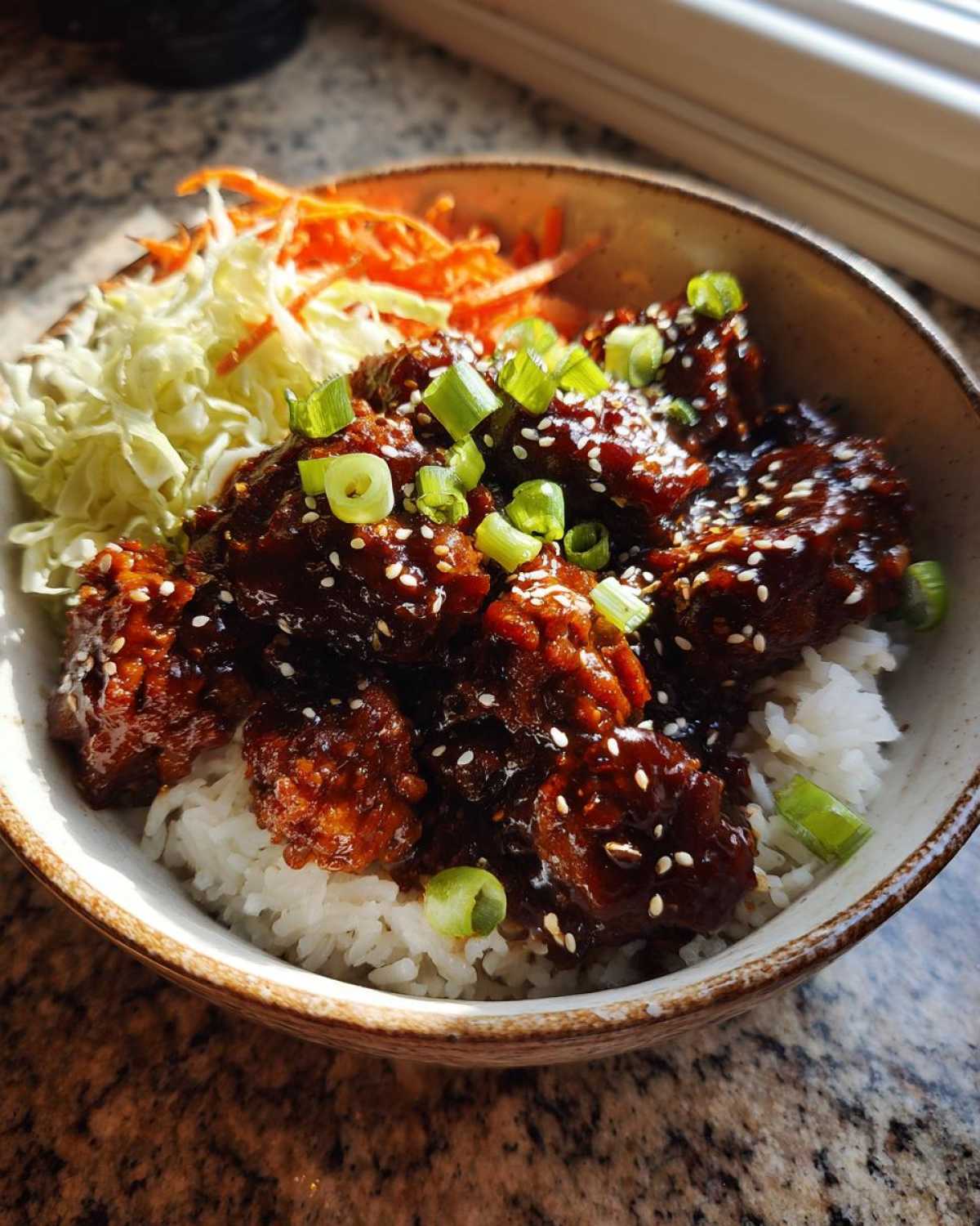 Close-up of a Sticky BBQ Chicken Bowl with Rice, featuring glazed chicken pieces, white rice, and shredded slaw.